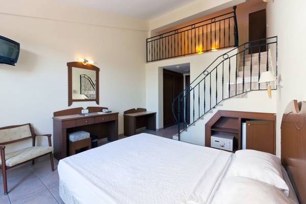 Zimmer im Süral Garden Hotel mit Bett, Schreibtisch, Spiegel und Fernseher.