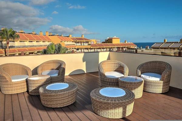Terrasse im Hovima Jardin Caleta mit Blick auf das Meer und Gebäude