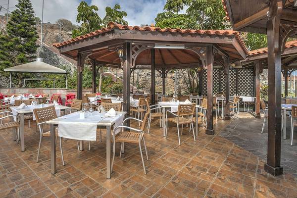 Außenbereich des Hovima Jardin Caleta Hotels mit Pavillon und Tischen.