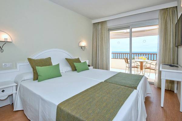 Doppelbettzimmer im Hovima Jardin Caleta Hotel mit Meerblick und Balkonmöbeln.