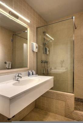 Badezimmer im Hovima Jardin Caleta Hotel mit Waschbecken, Spiegel und Glasdusche