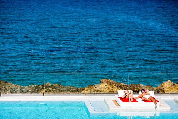 Paar, das am Pool im Abaton Island Resort & Spa liegt
