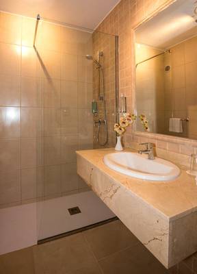 Badezimmer im Hovima Jardin Caleta Hotel mit Dusche, Waschbecken und Spiegel.