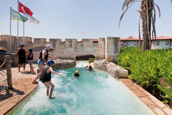 Besucher im Wasserrutschenbereich des Club Grand Side Hotels, einige mit Helmen und Schwimmwesten