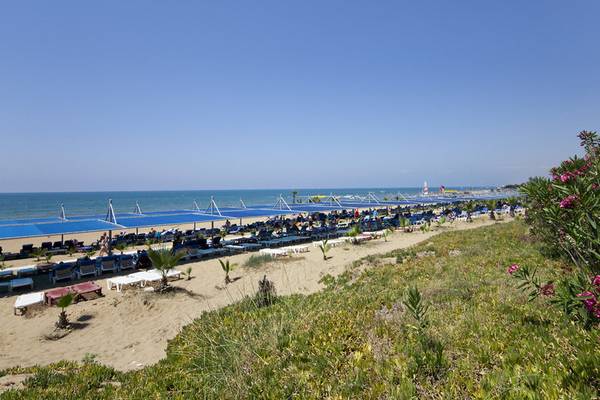 Strand des Club Grand Side Hotels mit vielen Liegen und Sonnenschirmen.