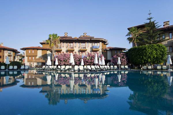 Der Swimmingpool des Club Grand Side Hotels mit Sonnenliegen und Schirmen.