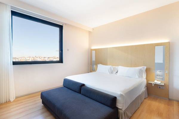 Ein modernes Zimmer im Barcelo Valencia Hotel mit Blick auf die Stadt.