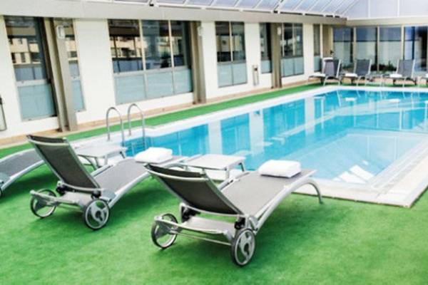 Außenpool im SH Valencia Palace Hotel mit Liegestühlen und Sonnenschirmen