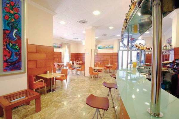 Innenbereich des DWO Valencia Hotels mit gepolsterten Stühlen, Tischen und einer Theke.