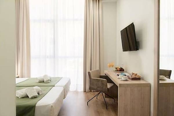 Doppelzimmer im Hotel DWO Valencia mit zwei Betten, Schreibtisch und Fernseher an der Wand.