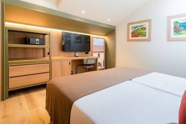 Hotelzimmer im DWO Valencia mit Doppelbett, Fernseher und Schreibtisch.
