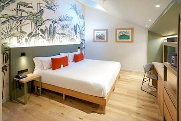 Schlafzimmer im DWO Valencia Hotel mit grünen Wandmalereien und einem großen Bett.