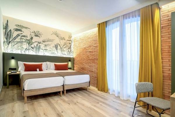 Doppelzimmer im DWO Valencia Hotel mit zwei Betten, Nachttischen, Lampen und Pflanzentapete.