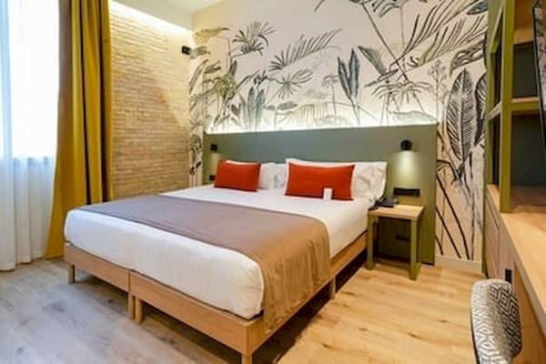 Ein Hotelzimmer im DWO Valencia Hotel mit grüner Wandgestaltung und einem Doppelbett.