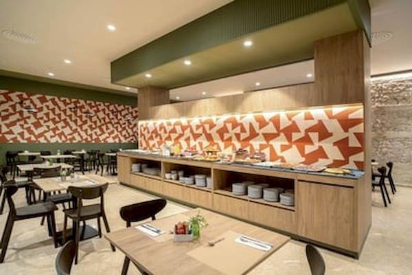 Frühstücksbuffet im DWO Valencia Hotel mit verschiedenen Gerichten und farbenfrohen Wänden.