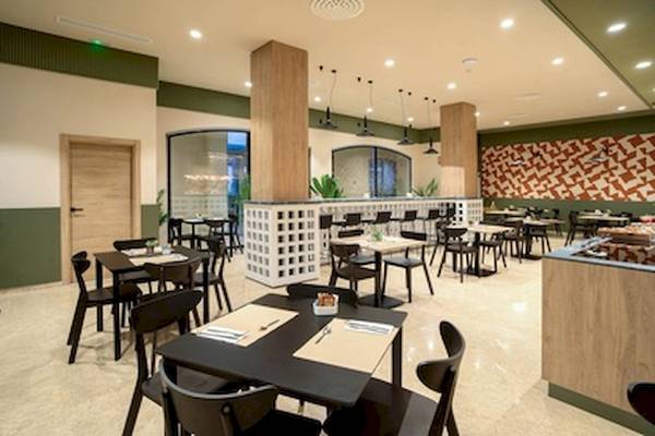 Innenansicht des Restaurants im DWO Valencia Hotel mit modernen Möbeln und geometrischen Wandmustern.