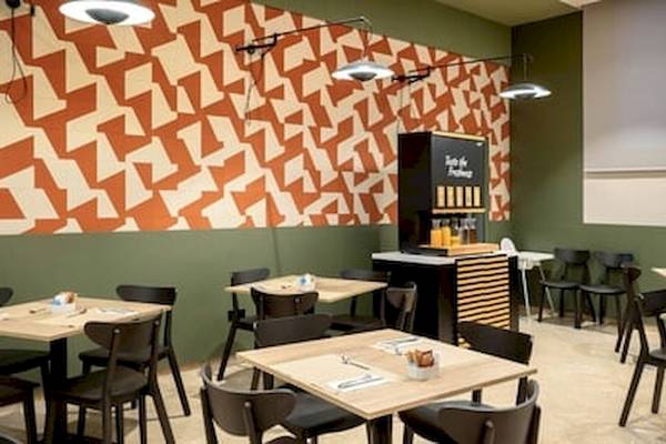 Essenbereich im DWO Valencia Hotel mit grünen Wänden und braunen Mustern.