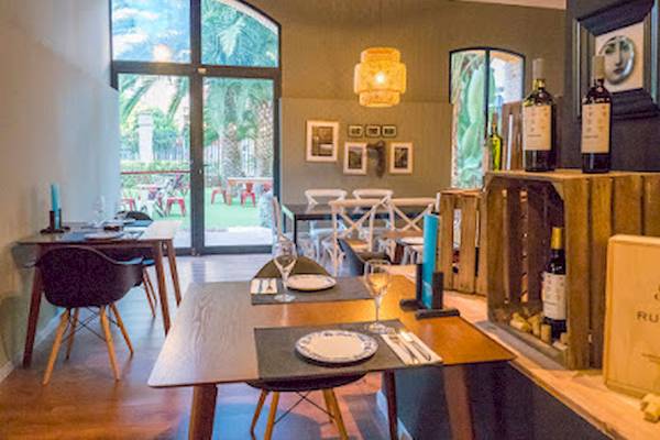 Innenbereich des DWO Valencia Restaurants mit Tisch, Stühlen und Blick auf eine Terrasse.