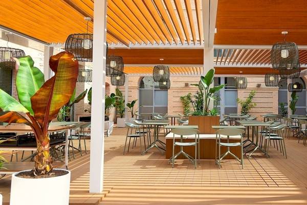 DWO Valencia Hotel Terrasse mit Tischen und Stühlen unter einer Holzdecke.