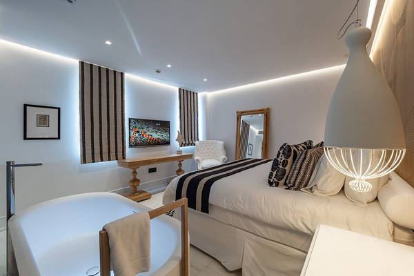 Hotelzimmer im Abaton Island Resort & Spa mit Badewanne, Bett, Fernseher und Möbeln.