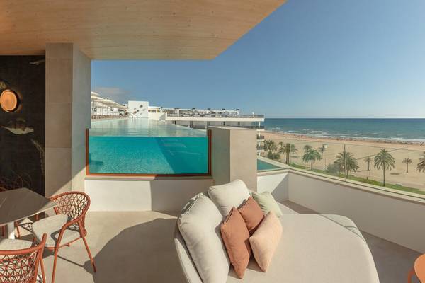 Balkon im RH Bayren & Spa Hotel mit Meerblick, Liegesofa und Esstisch draußen.