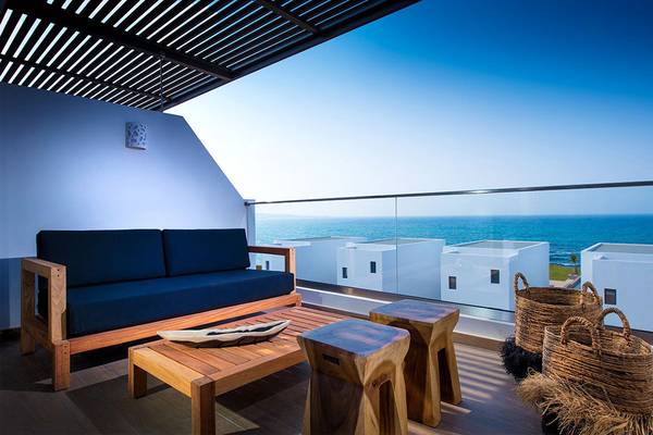 Terrasse mit Sofa und Tisch im Hotel Abaton Island Resort & Spa mit Blick auf das Meer.