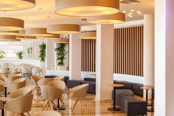 Innenbereich des RH Bayren & Spa Hotels mit runden Deckenleuchten und braunen vertikalen Streifen an der Wand.
