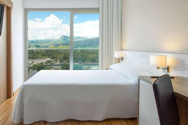 Zimmer im RH Bayren & Spa Hotel mit Bett und Ausblick auf die Berge