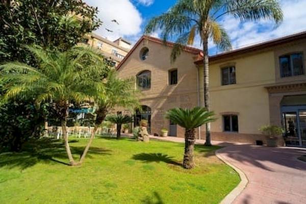 Vorderansicht des DWO Valencia Hotels mit Einfahrt und gepflegtem Rasen