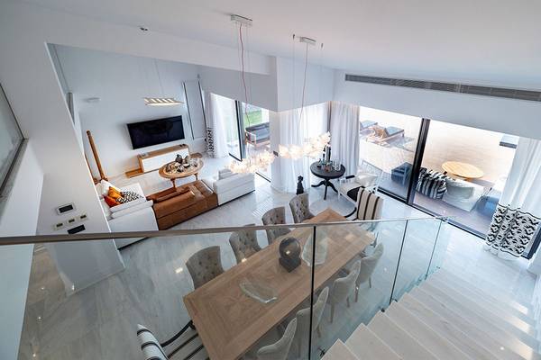 Innenansicht des Wohnbereichs des Abaton Island Resort & Spa mit Esstisch, Sofa und Fernseher.