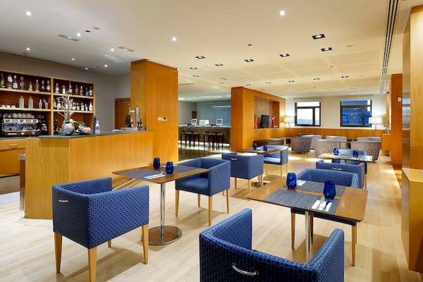 Barbereich im Eurostars Grand Valencia Hotel mit blauen Stühlen und Tischen.