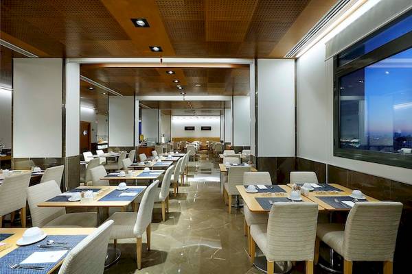 Innenansicht des Restaurants des Eurostars Grand Valencia Hotels mit gedeckten Tischen und Stühlen.