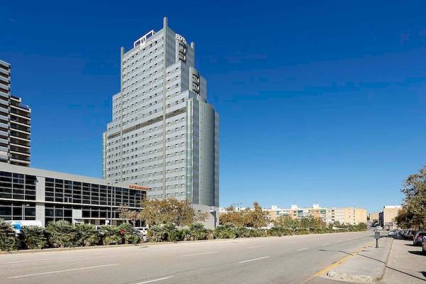 Eurostars Grand Valencia Hochhaus an einer Straße mit Bäumen und Gebäuden