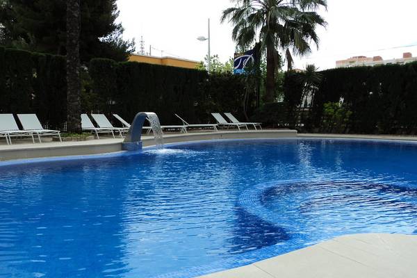 Ein Swimmingpool im Freien neben Liegestühlen und Bäumen im Principal Afilliated by RH Hotel.