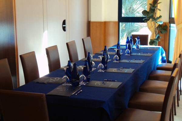 Konferenztisch im Hotel Principal Afilliated by RH mit blauer Tischdecke und blauen Flaschen.