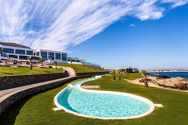 Außenbereich des Abaton Island Resort & Spa mit Infinity-Pool und Meerblick