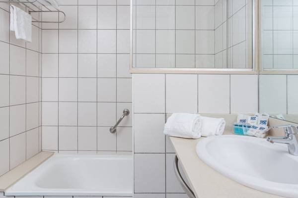 Modernes Badezimmer mit einer Dusche, Badewanne, Handtuchhalter und Waschbecken.