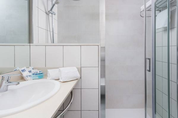 Badezimmer im Hotel Principal Afilliated by RH mit Dusche, Waschbecken und Handtüchern.