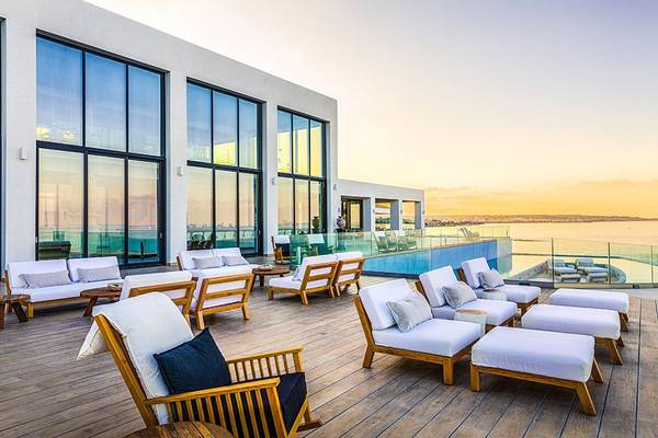Terrasse des Abaton Island Resort & Spa mit weißen Sofas und Meerblick.
