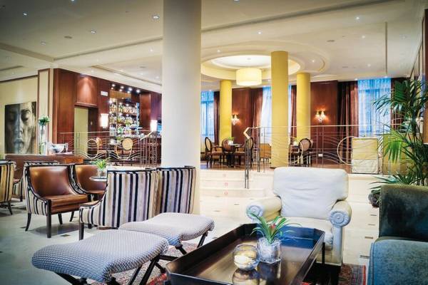 Innenansicht der Lobby des Westin Valencia Hotels mit Möbeln, Pflanzen und Sitzbereichen.