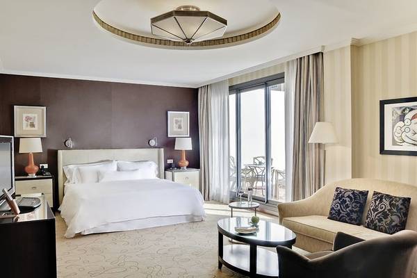 Schlafzimmer im Westin Valencia Hotel mit einem Bett, Sofa und einem großen Fenster.