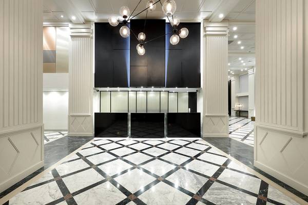 Lobby des Exe Rey Don Jaime Hotels mit schwarzen und weißen Marmorboden und großen Kronleuchter.