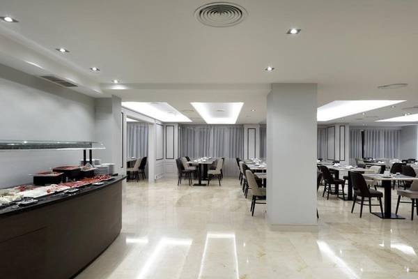 Frühstücksbuffet im Exe Rey Don Jaime Hotel mit vielen Tischen und Stühlen.