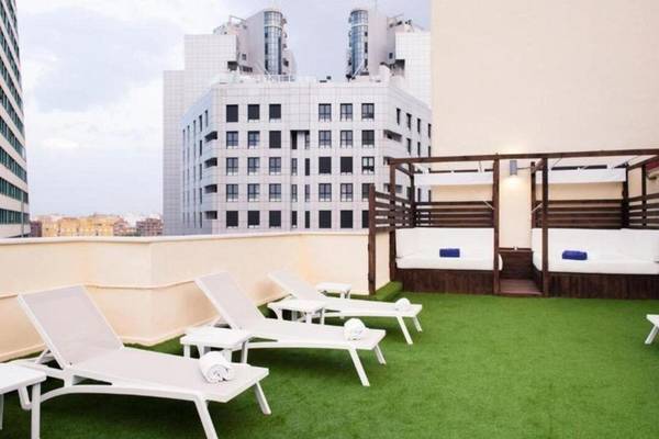 Dachterrasse des Exe Rey Don Jaime Hotels mit weißen Liegestühlen und grünem Kunstrasen.