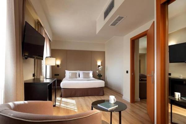 Hotelzimmer im Exe Rey Don Jaime mit Doppelbett, Fernseher, Tisch, Stuhl und Dekor.