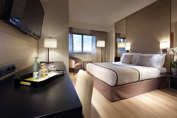 Exe Rey Don Jaime Hotelzimmer mit Bett, Schreibtisch, Fernseher und Lampe.