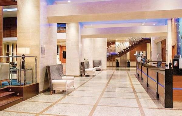 Foyer des Melia Valencia Hotels mit Sitzgelegenheiten und Rezeptionstresen.