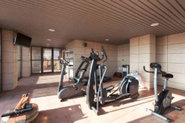 Fitnessbereich im Valencia Center Hotel mit Laufbändern, Fahrradtrainern und Hanteln.