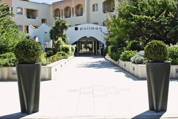 Einfahrt zum Pullman Hotel Almar Timi Ama Resort & Spa mit großen grauen Pflanzgefäßen