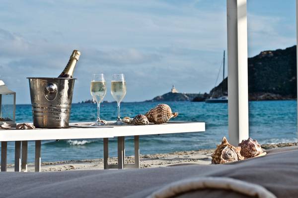 Eine Flasche Champagner und zwei Champagnerkelche auf einem Tisch am Strand des Almar Timi Ama Resort & Spa.